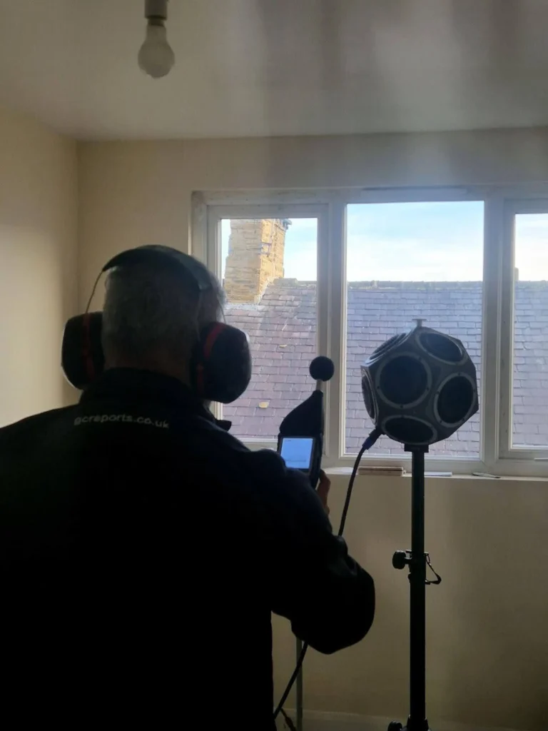 GC Reports engineer conducting airborne sound insulation testing using a dodecahedron omni-directional speaker for Building Regulations Part E compliance.