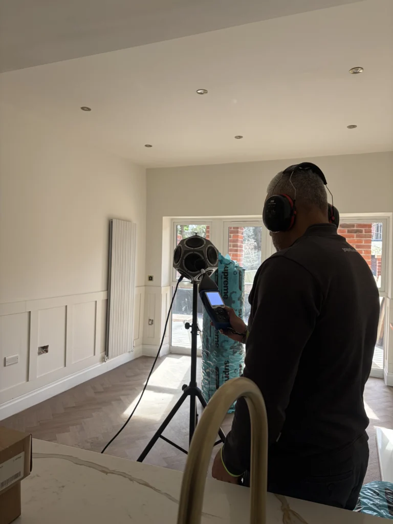 Garmesh Chand of GC Reports conducting on-site sound insulation testing for Building Regulations Part E compliance in a new-build residential property