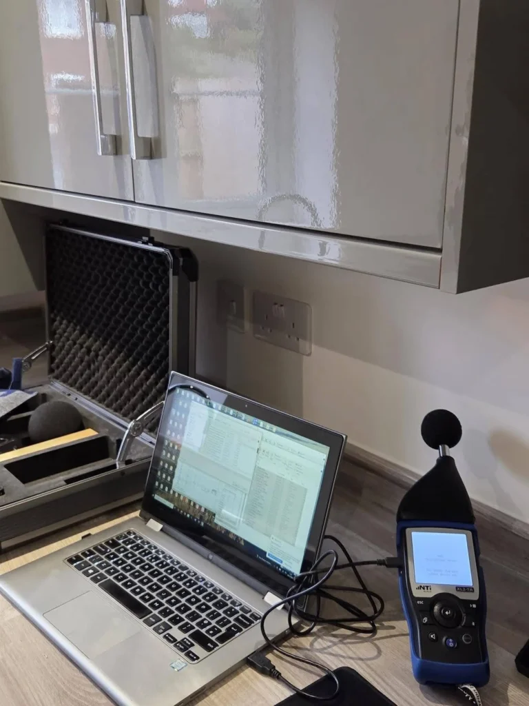 On-site acoustic measurement setup featuring an NTi Audio XL2 sound level meter and laptop for real-time sound insulation testing analysis
