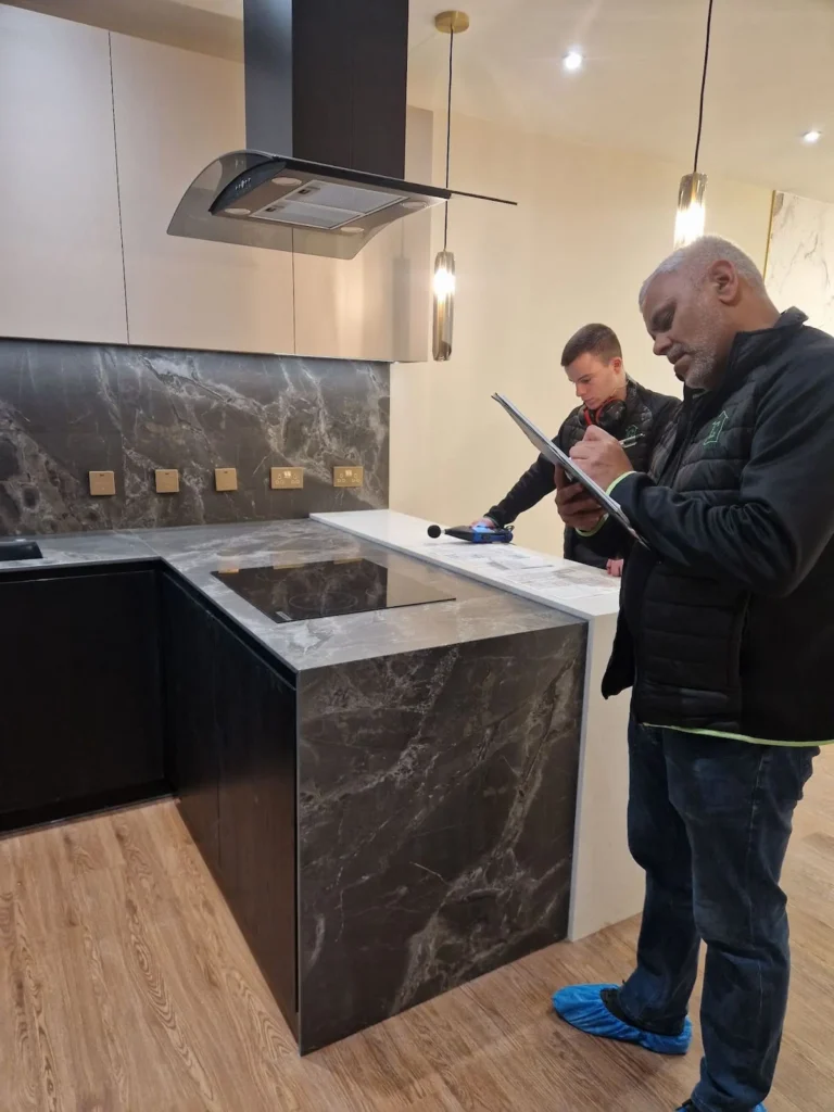 GC Reports team conducting on-site sound insulation testing in a luxury kitchen, recording acoustic measurements for Part E compliance