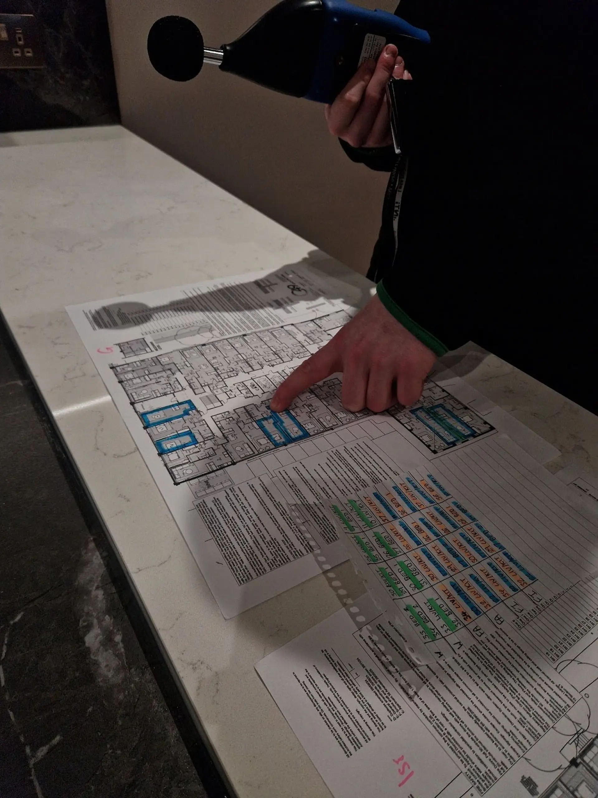 An acoustic engineer at GC Reports prepares floor plans to mark test positions for Part E sound insulation compliance