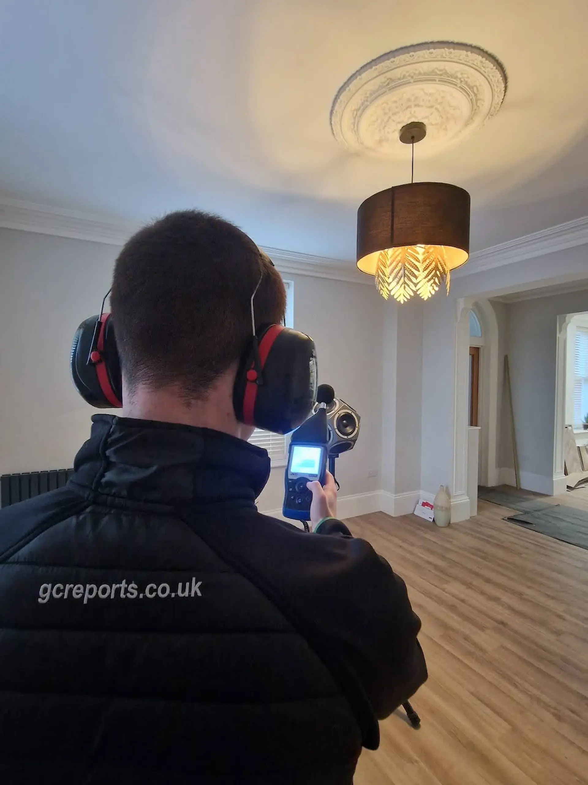 GC Reports engineer using a sound level meter to measure airborne sound insulation at the Copper Beech Court development